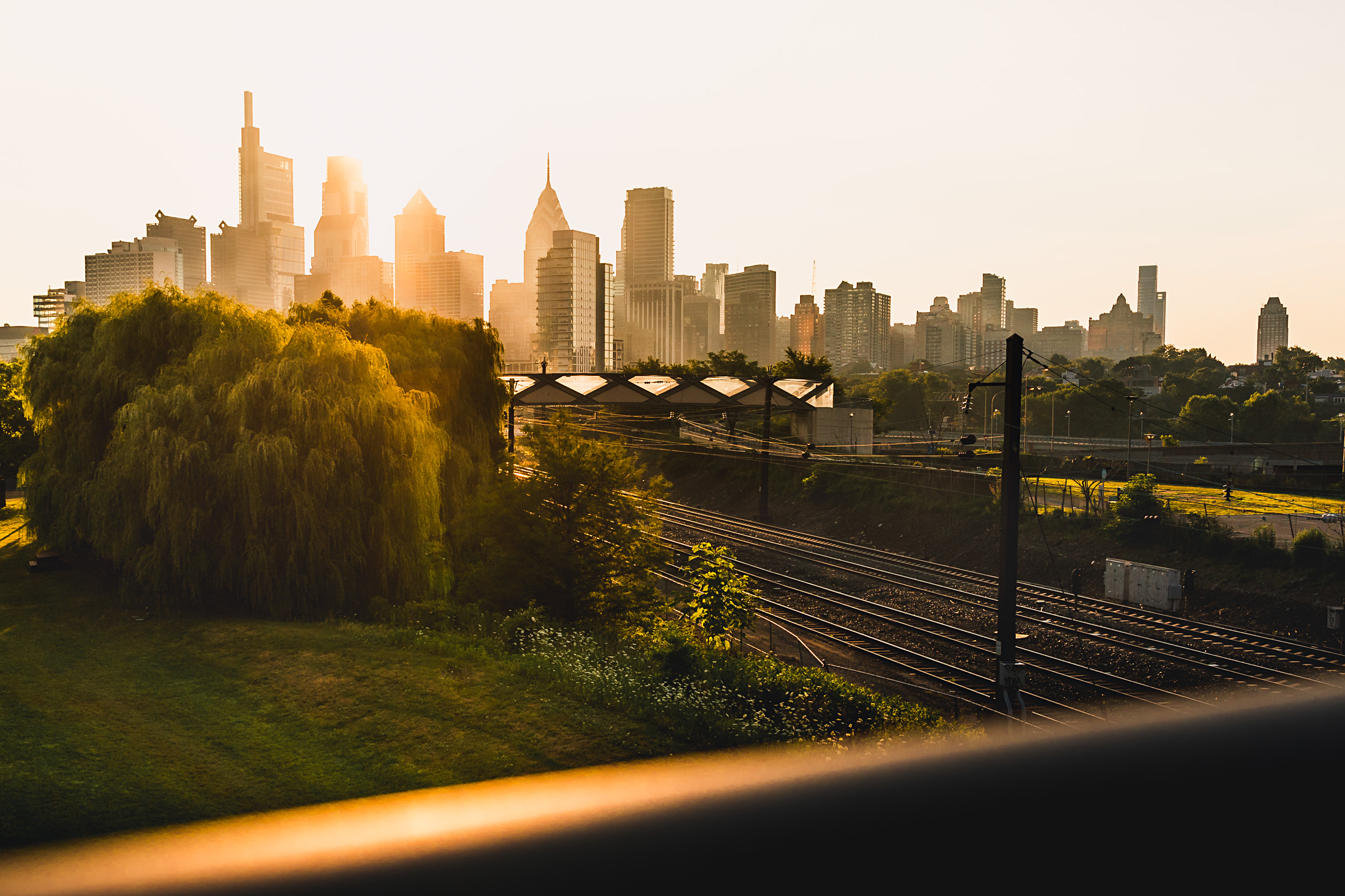 Philadelphia skyline from South Street Bridge at sunrise with railroad tracks in the foreground