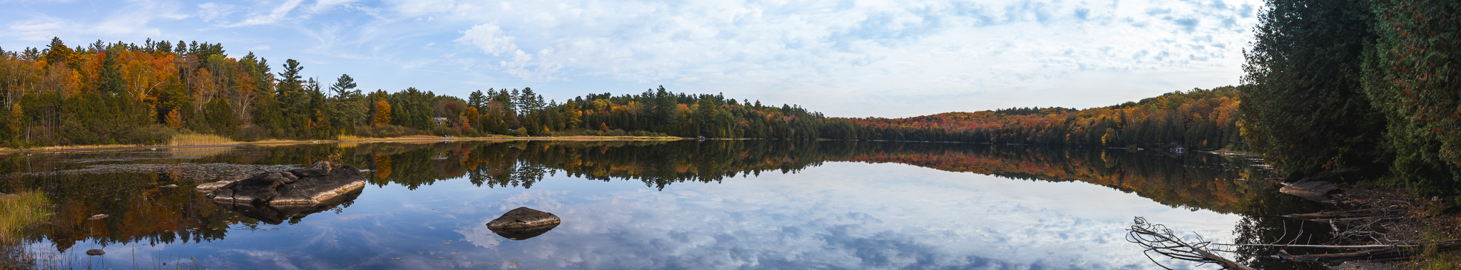 A panorama of Ewell Pond’s glasslike surface reflecting the orange, red, yellow, and green foliage