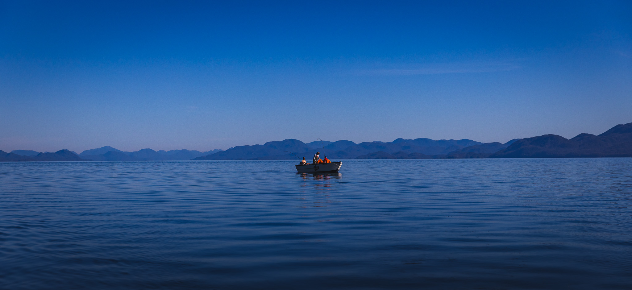 A lone boat of entrepreneurs fishing against a blue sky and sea