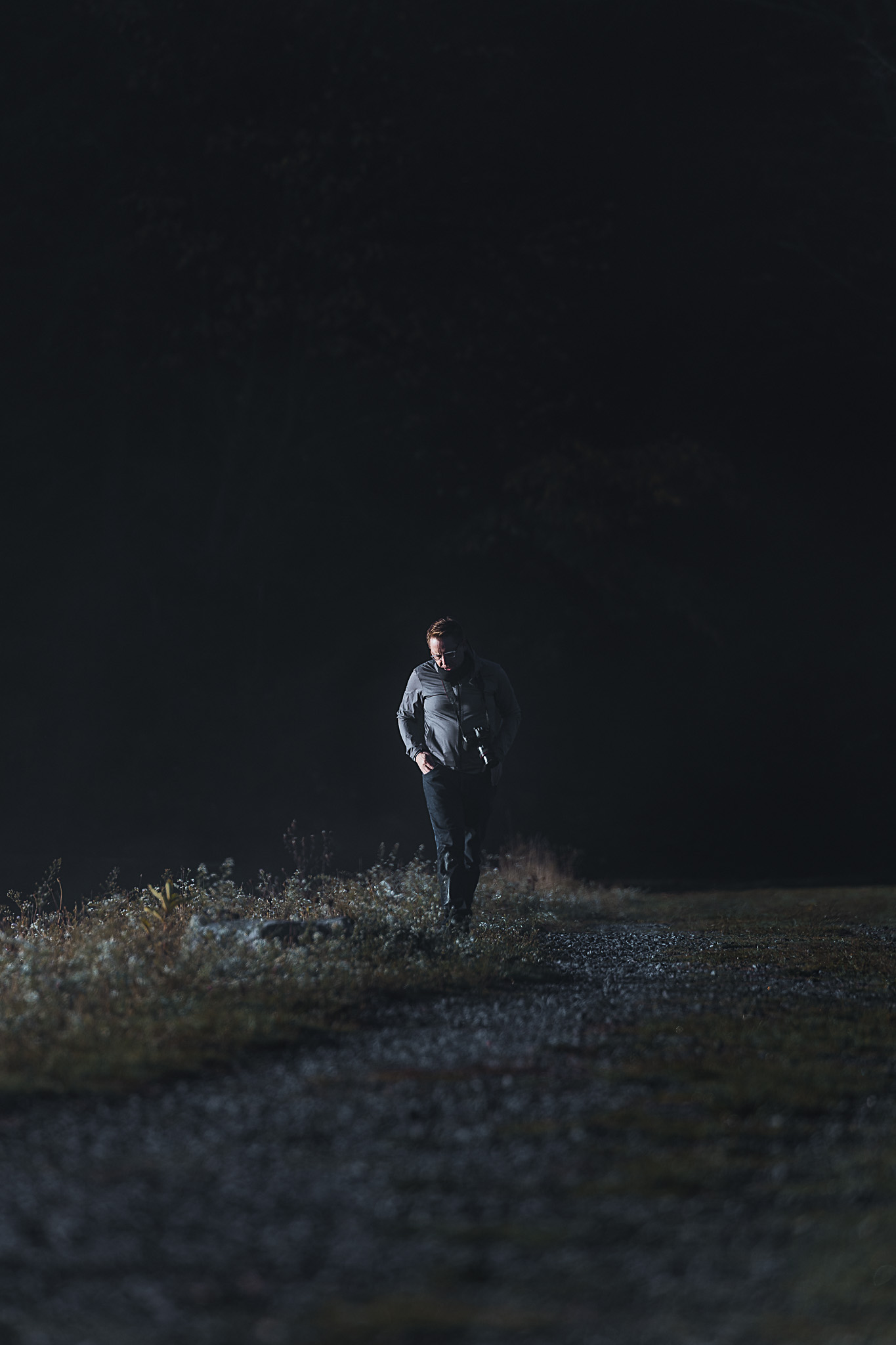 A man walking with a camera hanging around his neck
