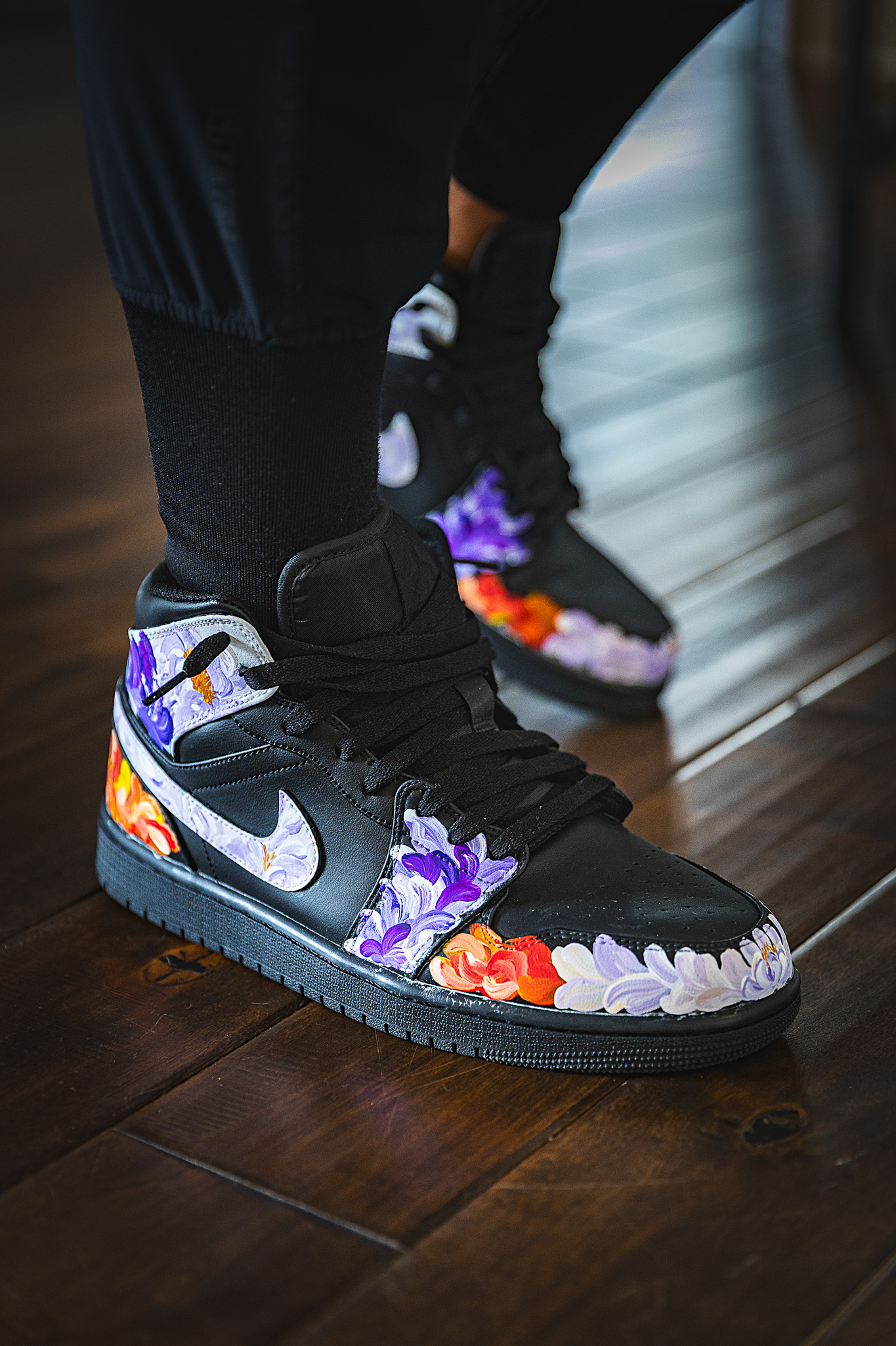 Custom black Jordan 1s with orange, white, and purple painted flowers