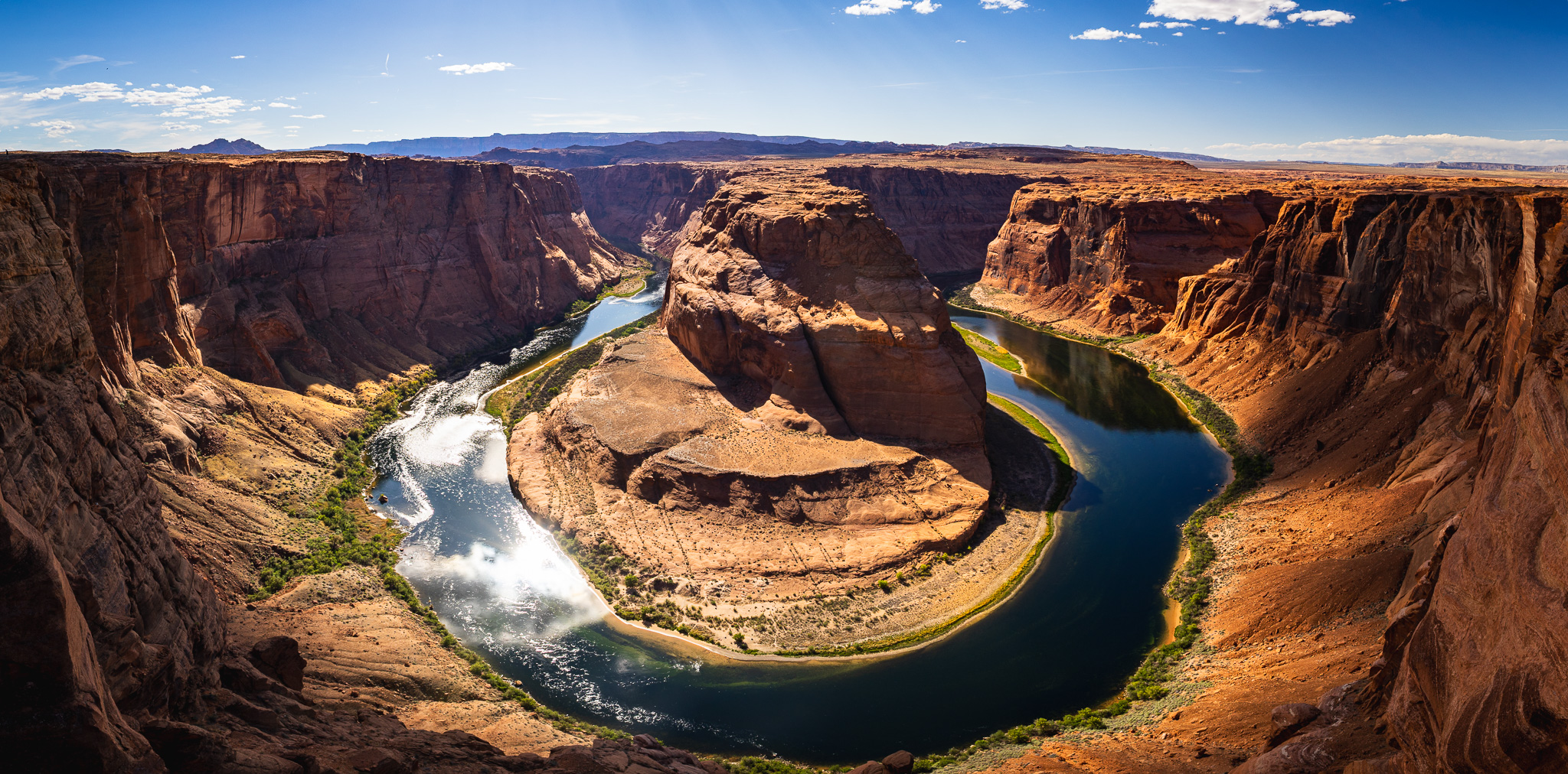 Mountainous cliffs with rock formation in the middle surrounded by water