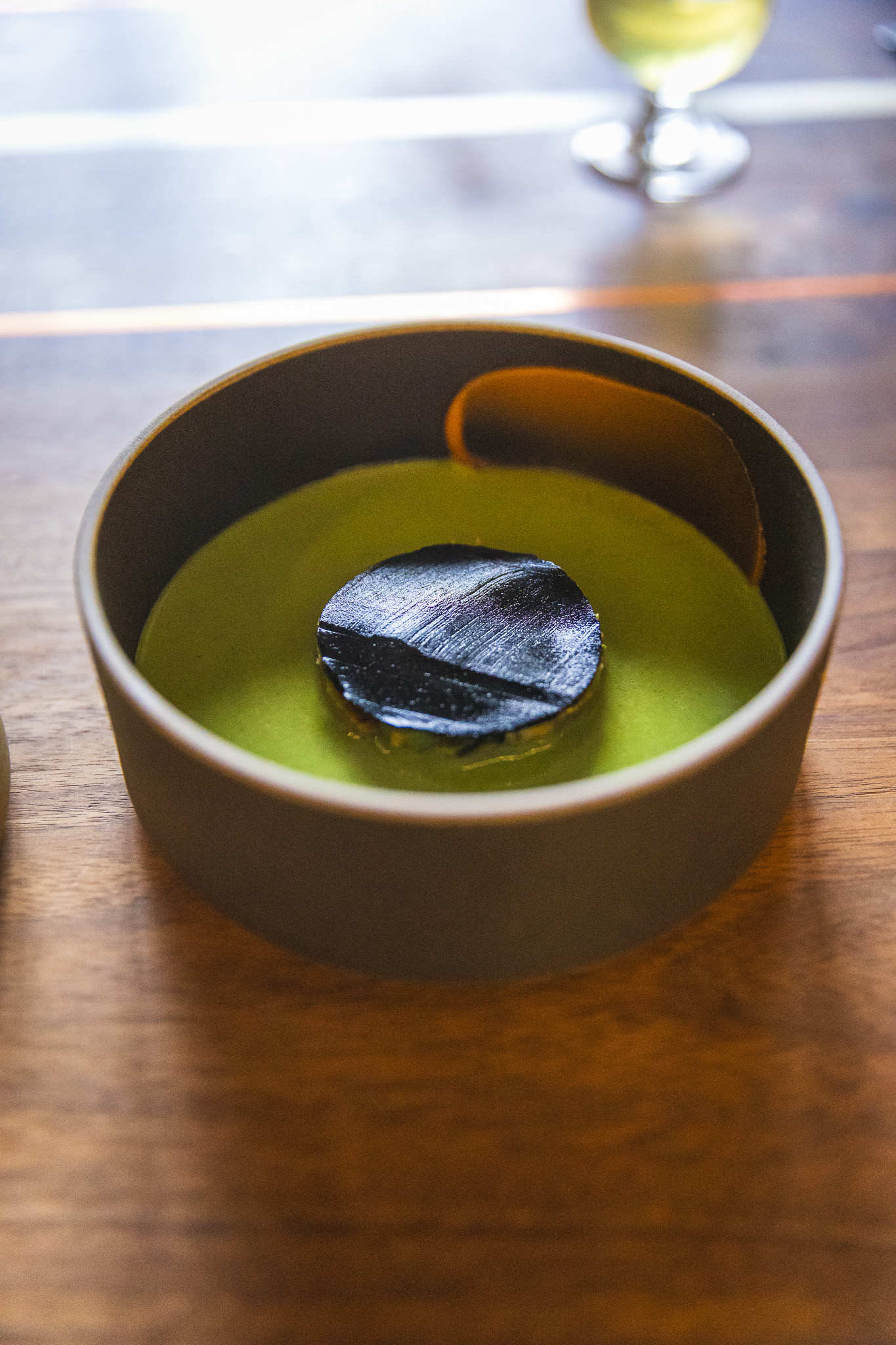 Disc-shaped food in a green broth