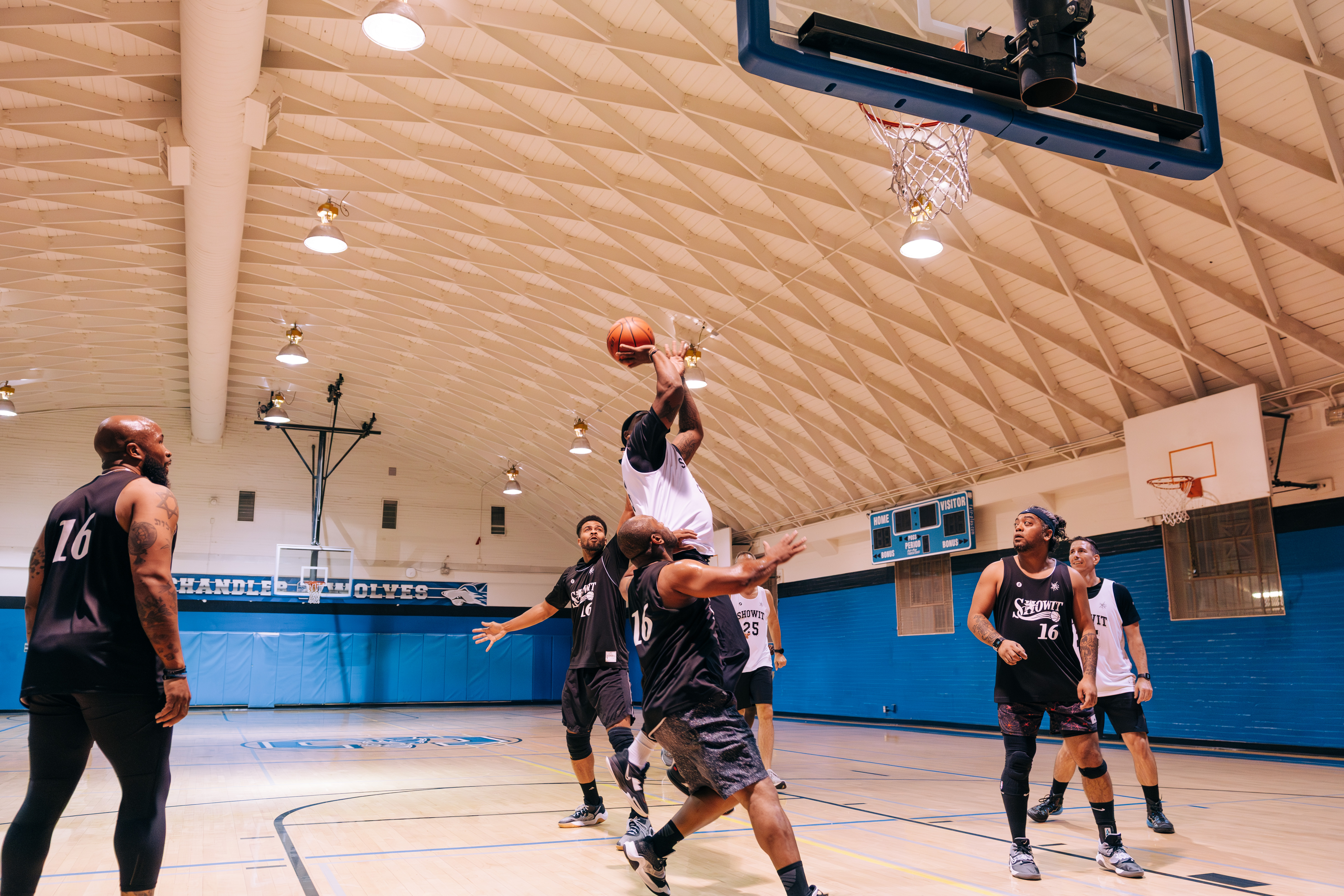 Man shooting a basketball with others watching