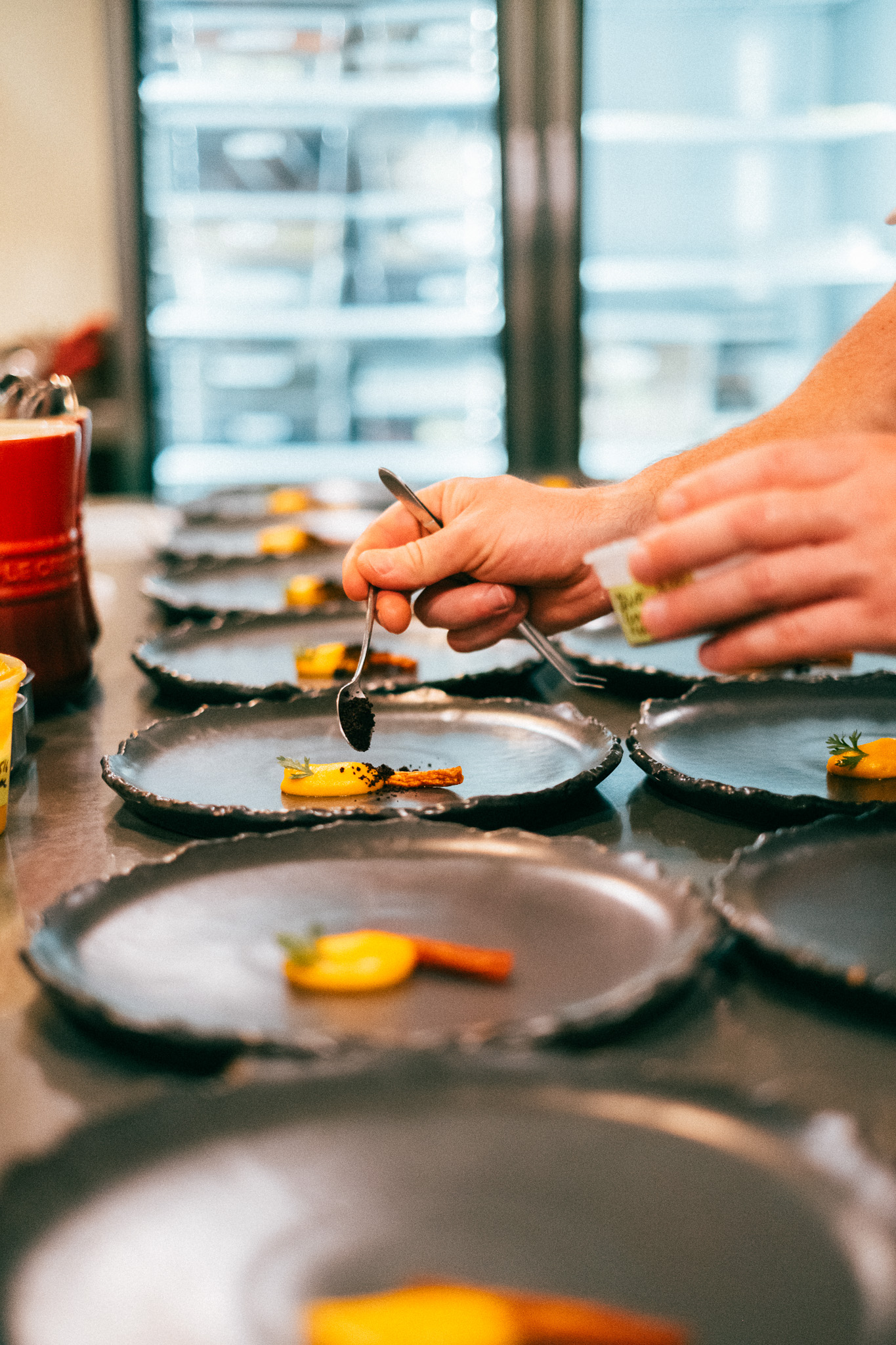 Adding sauce to a line of plates